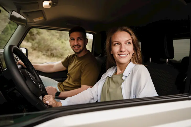 Jóvenes conducen un coche con muchos kilómetros