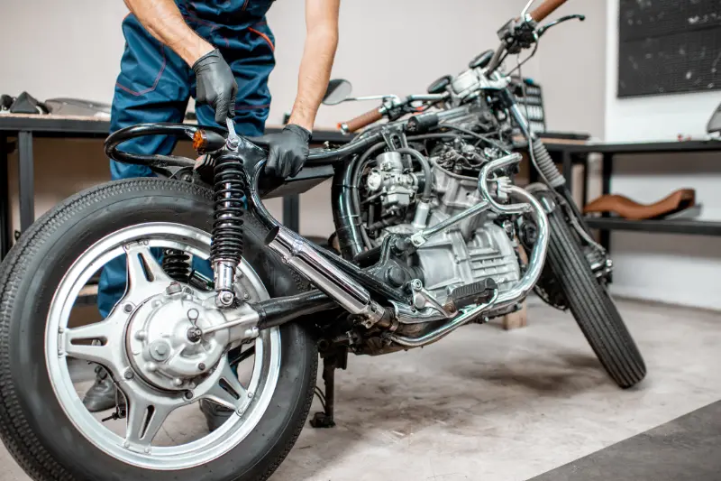 Mecánico revisa motocicleta usada
