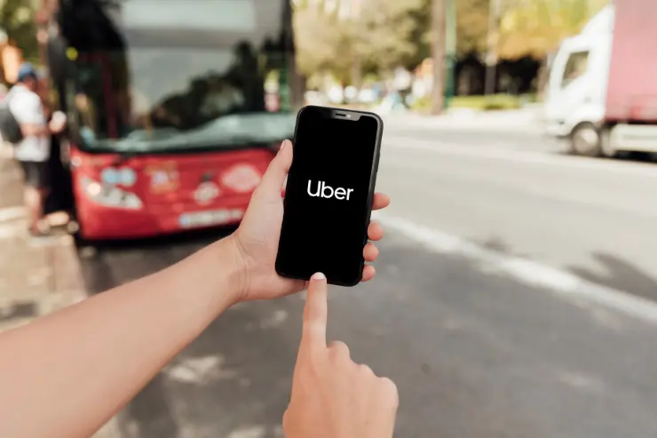 Mano de un hombre abriendo en su móvil la aplicación de uber
